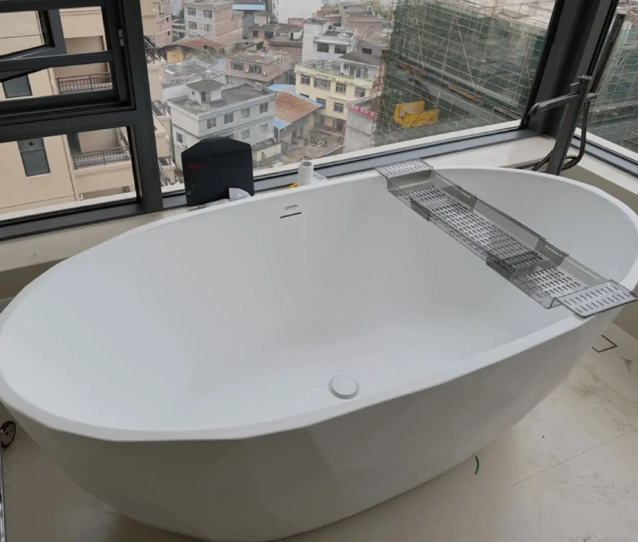 White bathtub installed beside a window